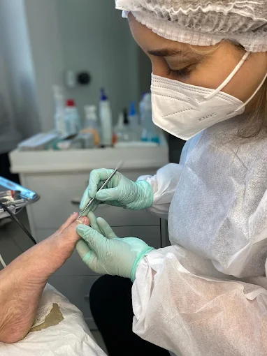 Kesya Cristine realizando um atendimento de podologia com equipamentos profissionais